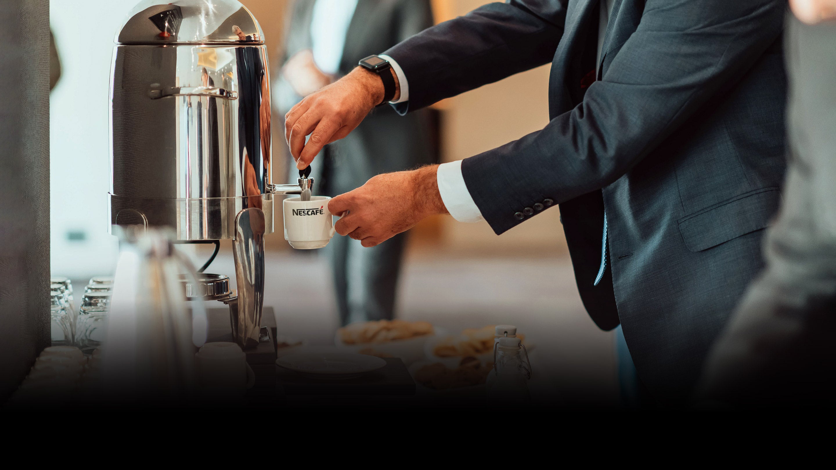 A man getting Nescafe coffee in hotel buffet.