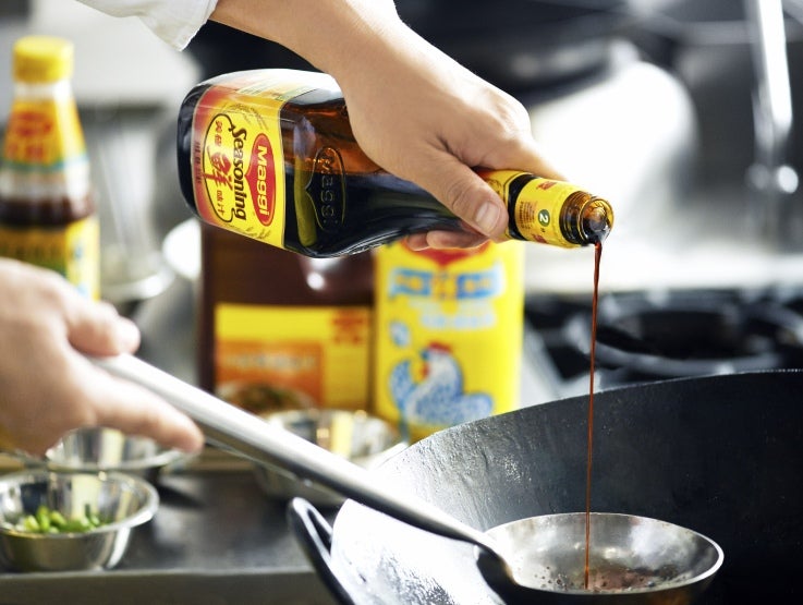 Chef adding Maggi Seasoning to his cooking.