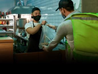 Delivery man getting food at the restaurant.