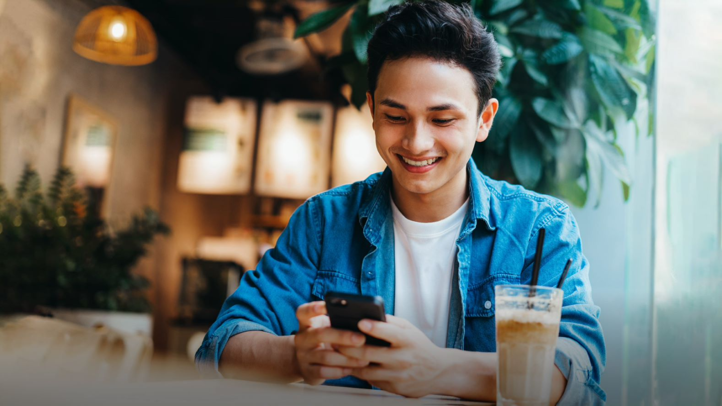 A man in the cafe using his mobile phone